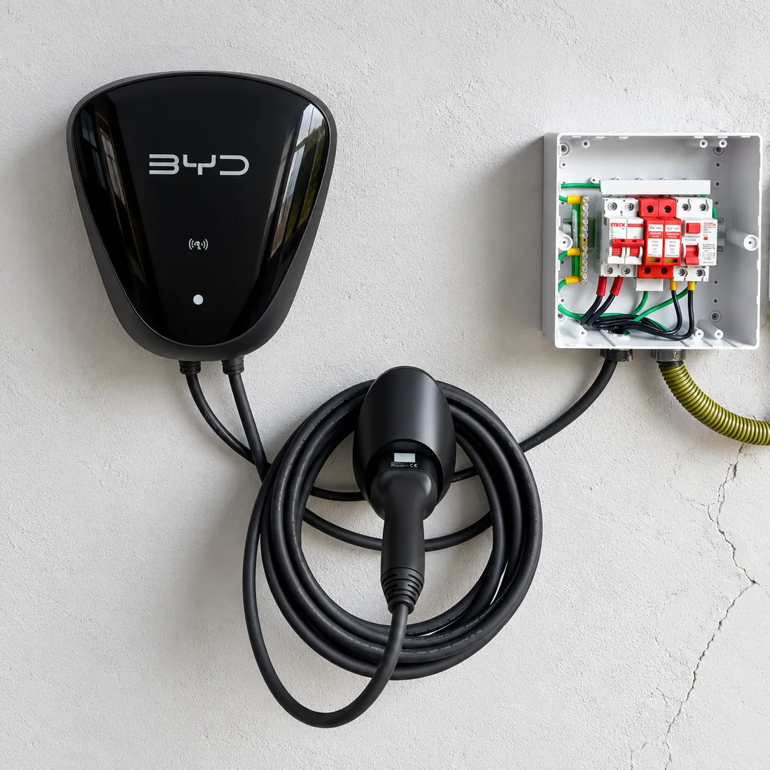 Wallbox de carro elétrico na parede ao lado do quadro de proteção aberto, com DPS