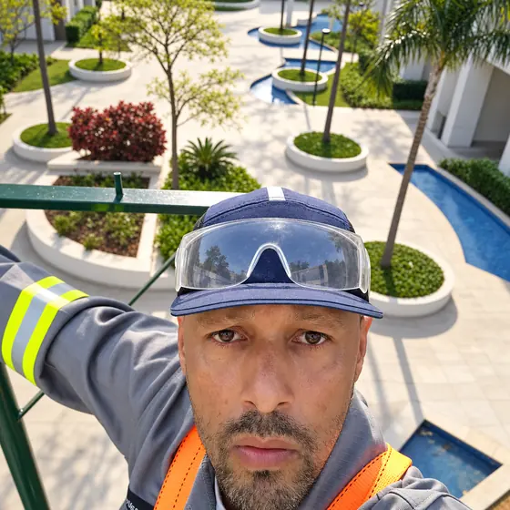 William no alto de um condomínio com jardim e espelhos d'água ao fundo